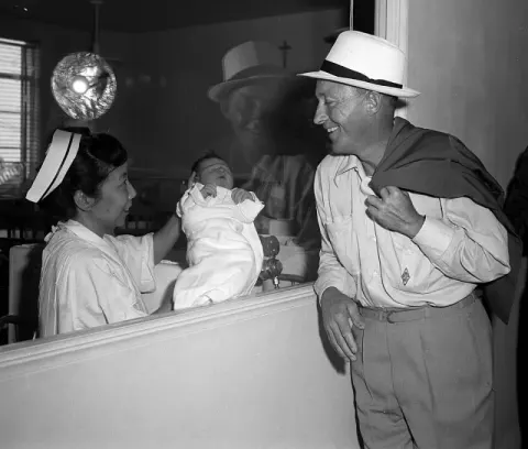 Bing Crosby at his newborn son Harry in the nursery of a Los Angeles hospital (1958)
